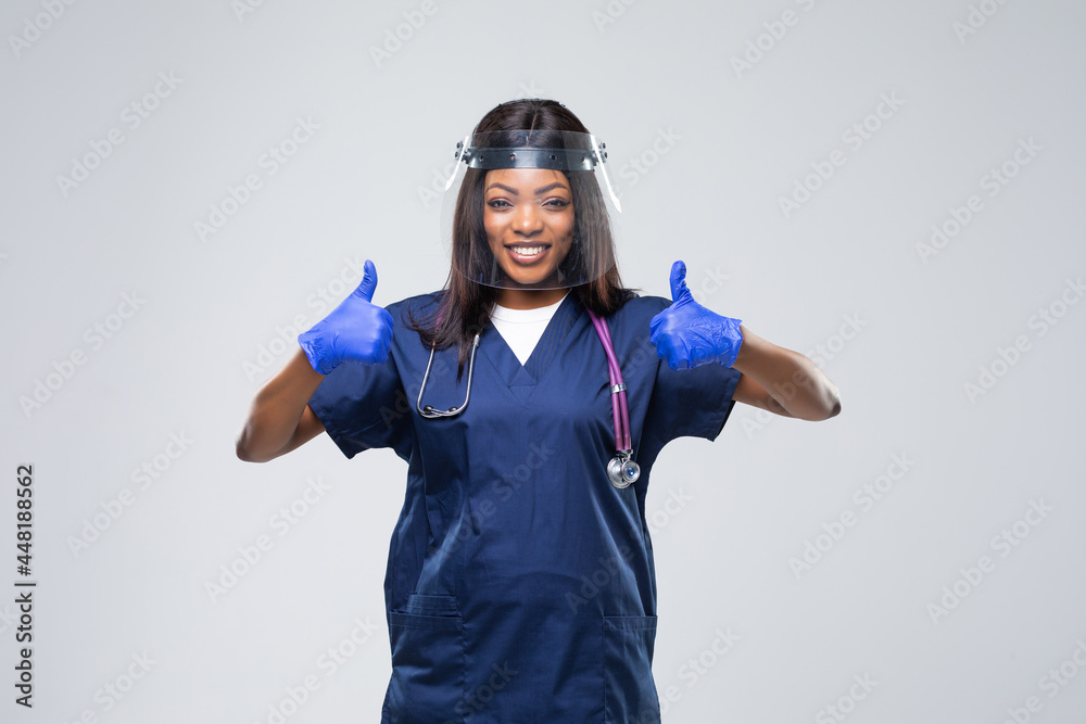 Medical concept of young beautiful female doctor with protective face mask, waist up. Woman hospital worker looking at camera and smiling, studio, grey background Medical concept of young beautiful female doctor with protective face mask, waist up. Woman hospital worker looking at camera and smiling, studio, grey background
