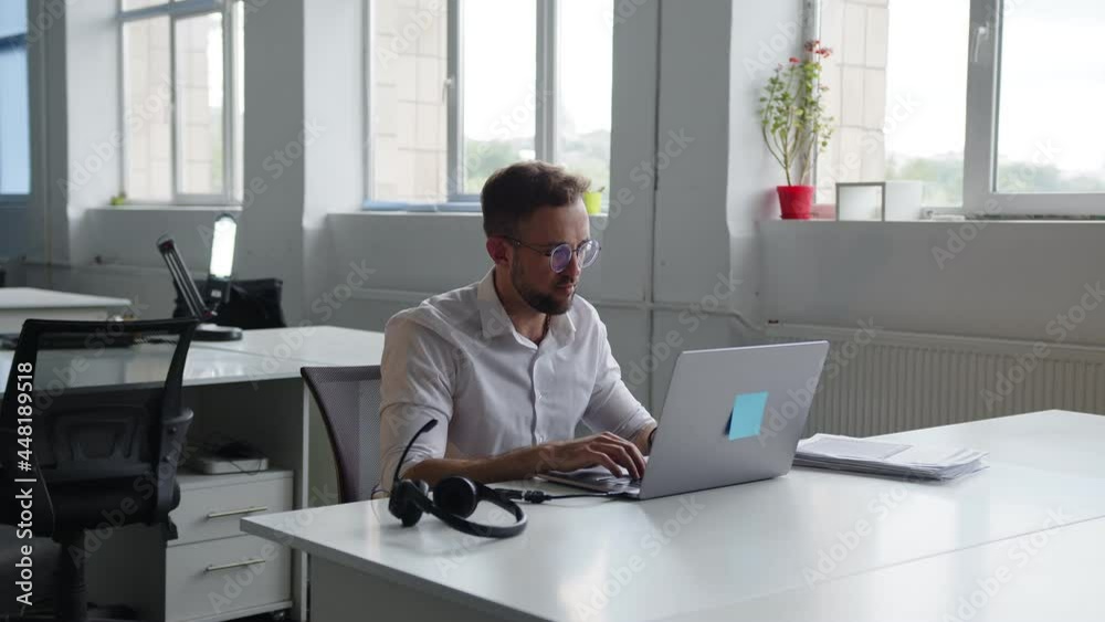 Man sits at the grey laptop and typing on it Man sits at the grey laptop and typing on it