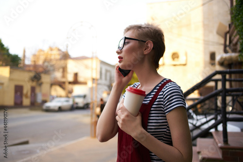 woman with short hair cup of coffee with glasses talking on the phone