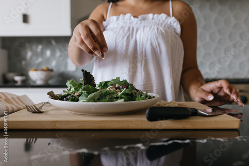 Woman preparing salad in luxury kitchen photo