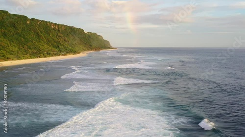 Aerial drone footage of the stunning Nyang Nyang beach with a rainbow in late afternoon in Bali, Indonesia. photo