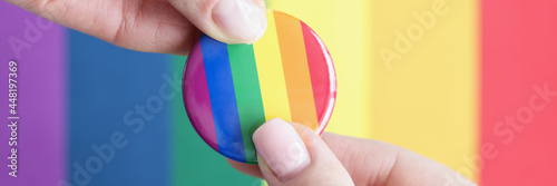 Obraz na płótnie Two people hold lgbt sign against background of flag of sexual minorities