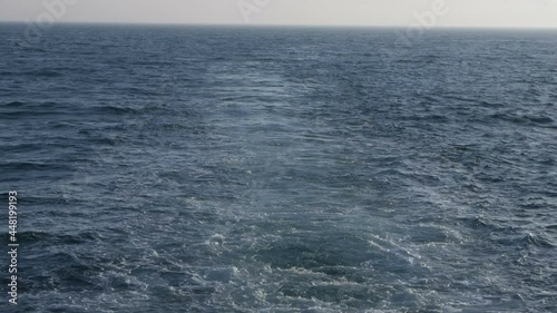 A motor boat cuts through the clear sea water in motion. Slow motion.