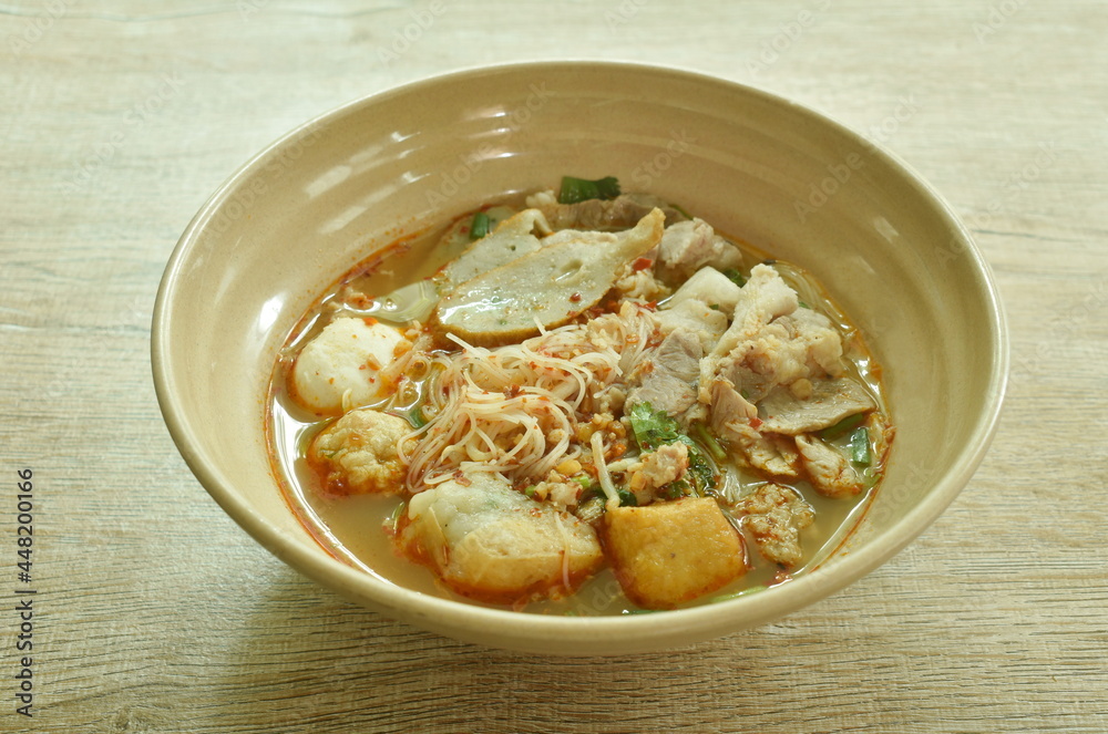 spicy vermicelli noodles topping slice boiled pork and ball in tom yum soup on bowl spicy vermicelli noodles topping slice boiled pork and ball in tom yum soup on bowl