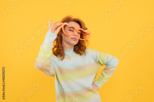 happy redhead woman wear funny party glasses on yellow background, party fun
