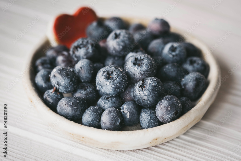 blueberries in a small ceramic bowl with a red heart decor blueberries in a small ceramic bowl with a red heart decor