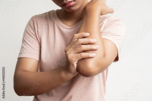woman hand with numbness and pain in the elbow feels sore and tingling due to numbness in the nerve endings, a side effect of Guillain-Barre Syndrome after vaccination against COVID-19 photo