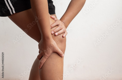 A woman supporting herself from numbness, muscle weakness, pain, and tingling in the knee nerve endings. This is a side effect of Guillain-Barre Syndrome after vaccination against COVID-19