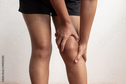 A woman supporting herself from numbness, muscle weakness, pain, and tingling in the knee nerve endings. This is a side effect of Guillain-Barre Syndrome after vaccination against COVID-19 photo