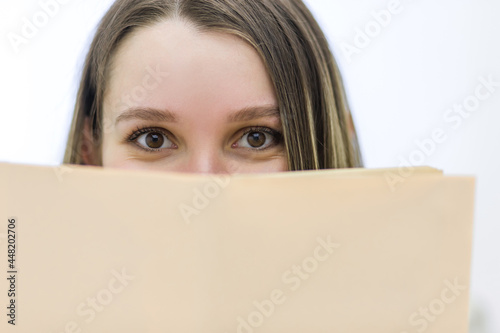 Woman hiding her face with a book. © Andrii