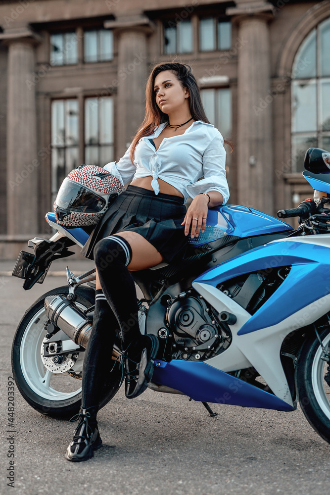 Shot of woman with motorbike in summertime outside