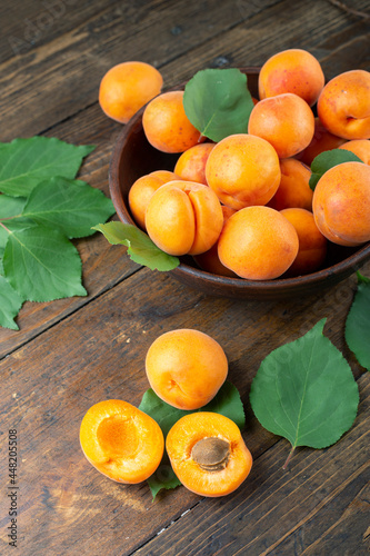 Delicious ripe apricots in a clay bowl on the table close-up.