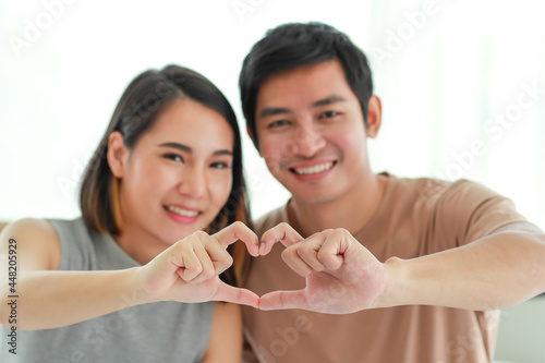 Happy Asian couple taking selfie at home