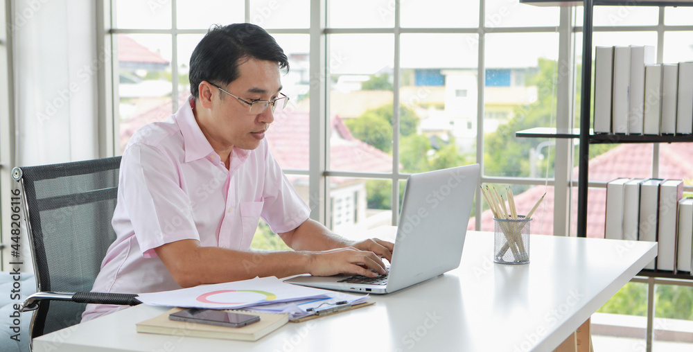 Serious ethnic businessman working on laptop in office Serious ethnic businessman working on laptop in office