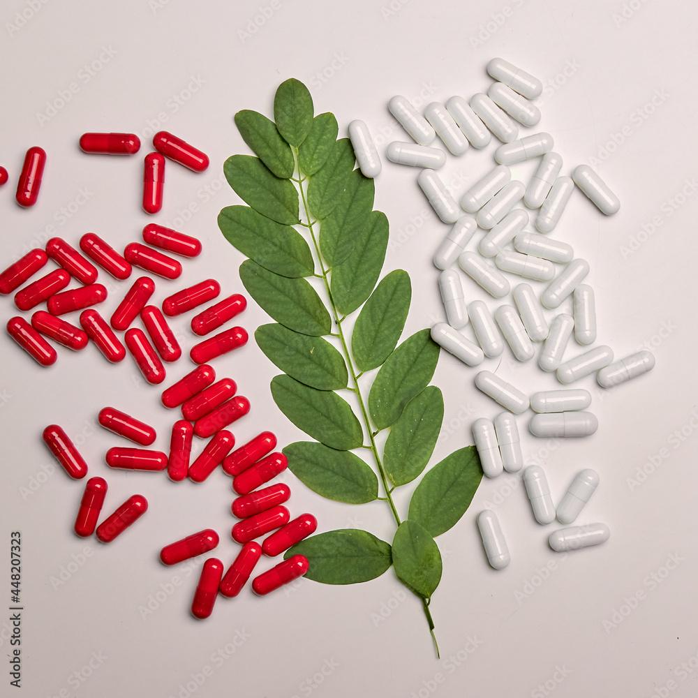 Many white and red capsule pills on a colorful background. Health supplements and medicines