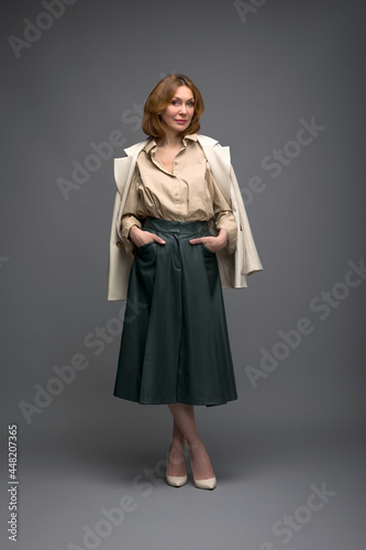 full length portrait of a fashionable aged woman isolated on grey