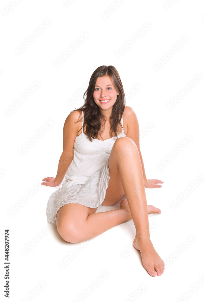 Cheerful young woman wearing a short summer skirt and a white top, isolated in front of white studio background Cheerful young woman wearing a short summer skirt and a white top, isolated in front of white studio background