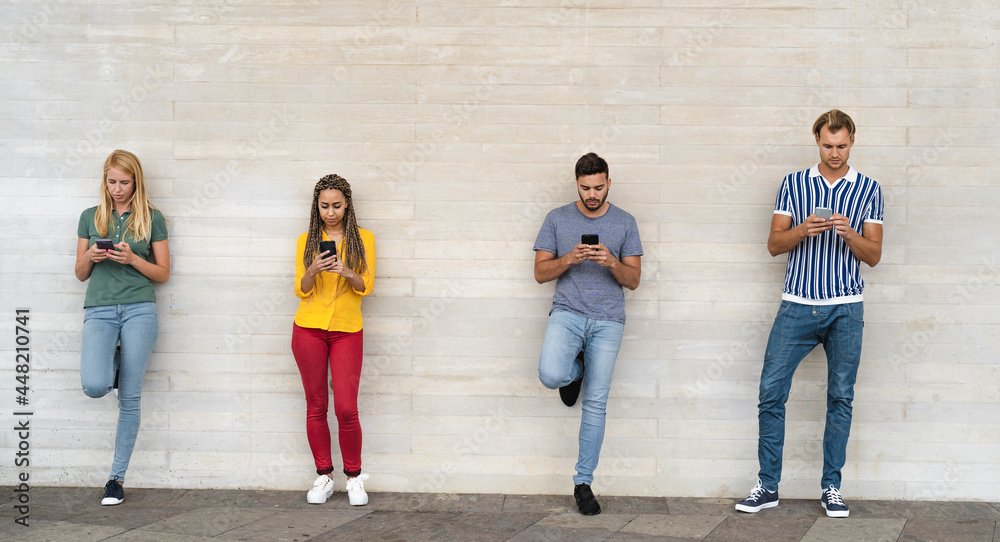 Obraz premium Young multiracial group of friends using mobile smartphone outdoor - Youth millennial lifestyle concept
