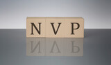 Net present value NPV concept, wooden word block on the grey background