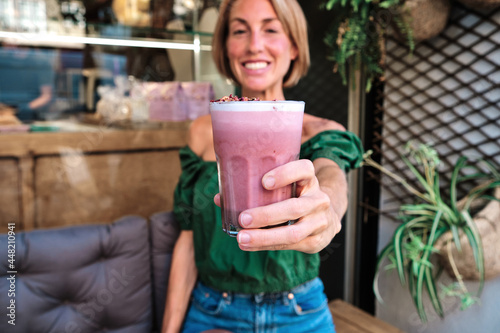 young adult skinny woman with healthy pnik smoothie in her hands photo