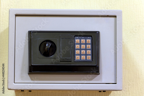 A small safe with a dial is mounted on the wall.