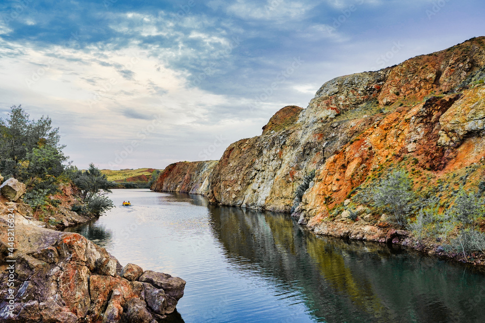 Obraz premium Boat driving on the river in the distance, lake in the canyon in autumn, mesmerizing landscape, wallpapers