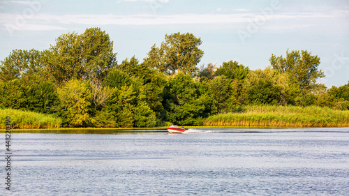 boat with a motor rushing along the river photo