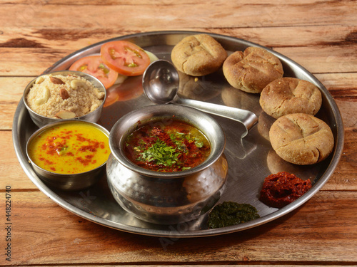 Rajasthani Traditional Cuisine Dal Baati Also Know as Dal Bati or Daal Baati Churma on Wooden Background. selective focus photo