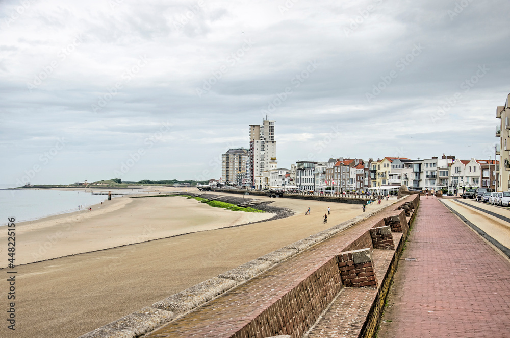 Vlissingen, The Netherlands, July 25, 2021: view along the city's seafront with a sandy beach, an asphalt slope, a brick seawall and architecture in various styles