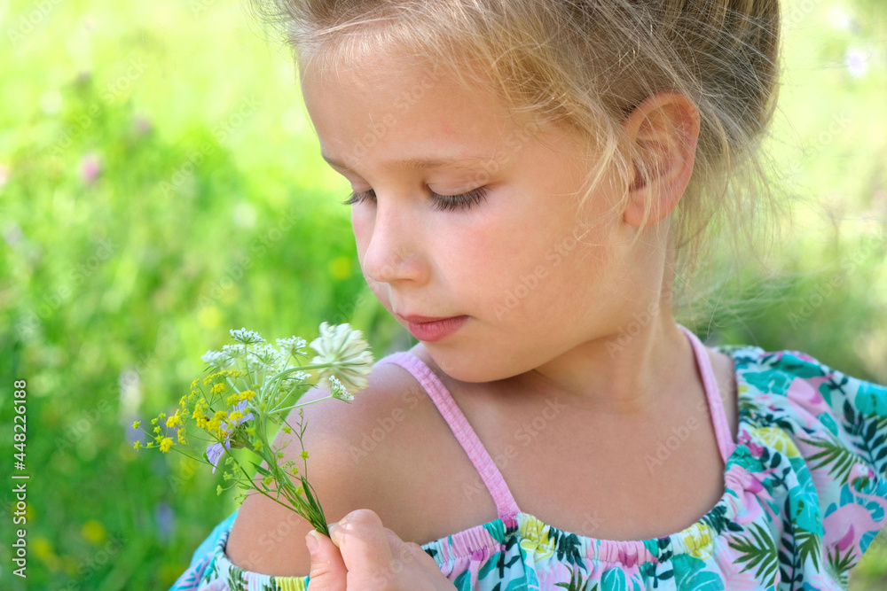 Little girl picking summer flowers in a field. Happy child enjoying nature outdoors Little girl picking summer flowers in a field. Happy child enjoying nature outdoors