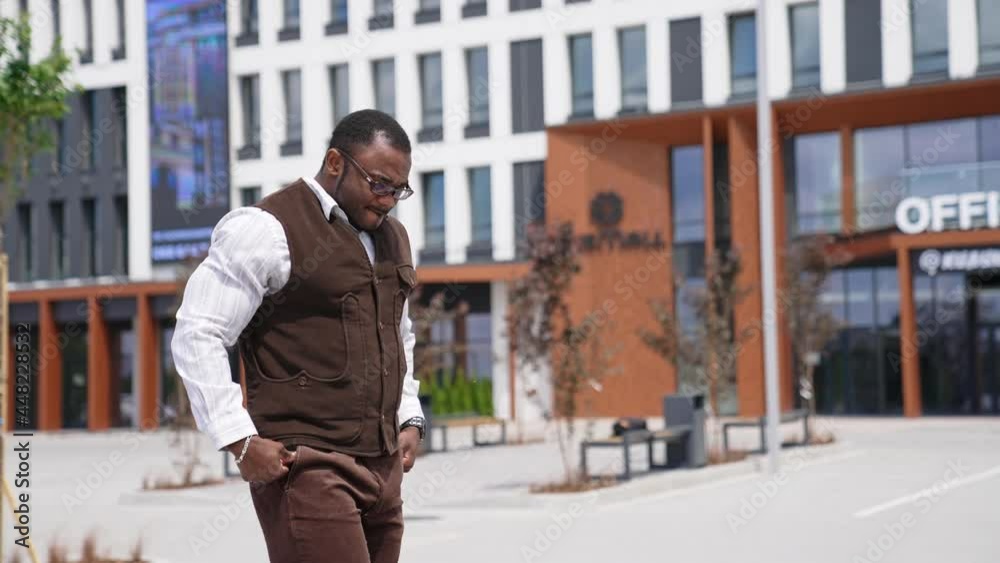 African guy walking at urban street. African american business man answering phone call outdoors. Smiling afro male talking on smartphone outside. African guy walking at urban street. African american business man answering phone call outdoors. Smiling afro male talking on smartphone outside.