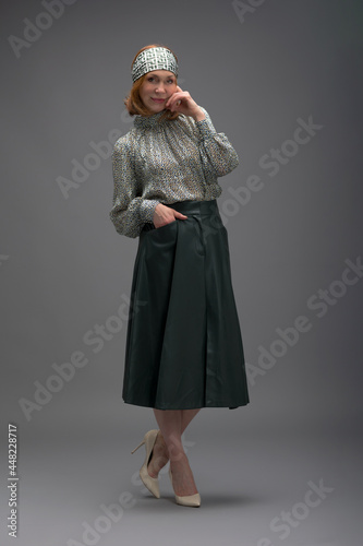 full length portrait of a fashionable aged woman isolated on grey