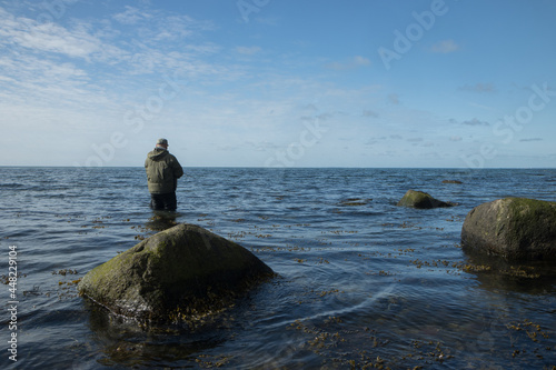 angler with spinning rod by the Baltic Sea, coastal fishing, sea trout