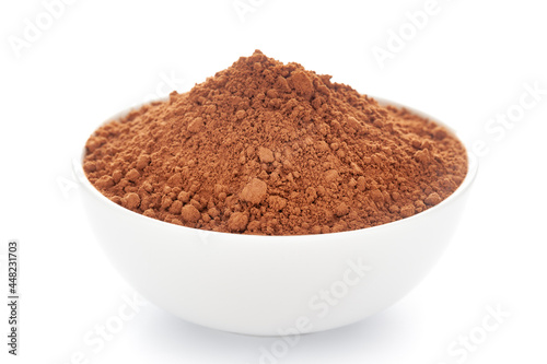 Close-up of organic powder of cocoa seed(Theobroma cacao) in a white ceramic bowl over white background.