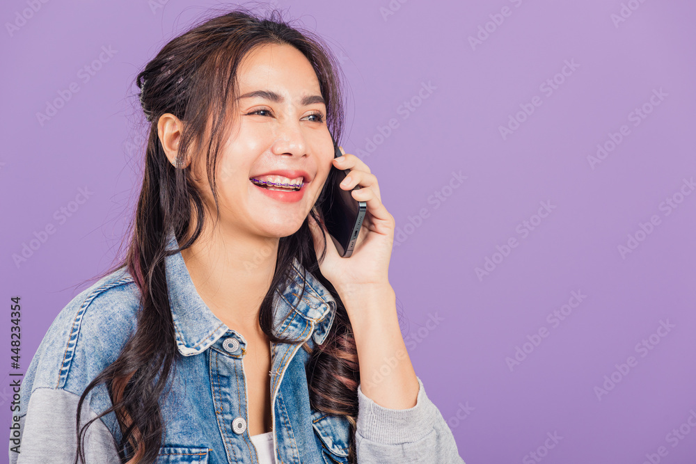 .Portrait of Asian beautiful young woman confident smiling on phone call with smartphone, Happy lifestyle female teen calling and talking to her friends, studio shot isolated on purple background .Portrait of Asian beautiful young woman confident smiling on phone call with smartphone, Happy lifestyle female teen calling and talking to her friends, studio shot isolated on purple background