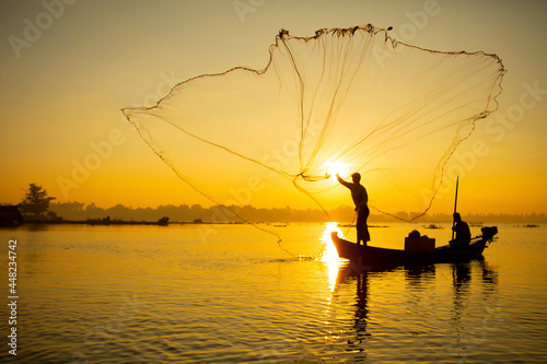 fisherman throwing his net at sunrise