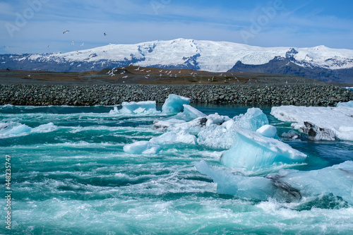 Glacial river at the Jokulsarlon Glacier Lagoon in Iceland with blue-green icebergs