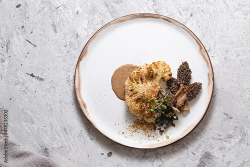 Cauliflower steak with morels on plate, restaurant dish, copy space photo