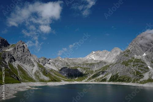 scenic mountain summer with bright blue sky and lake in the alps