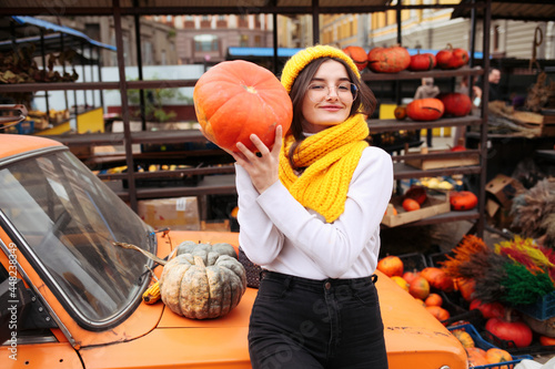 Young pretty woman holding orange halloween pumpkin. 