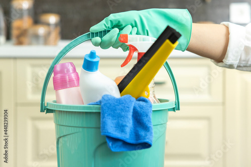 Woman holding cleaning products with glove