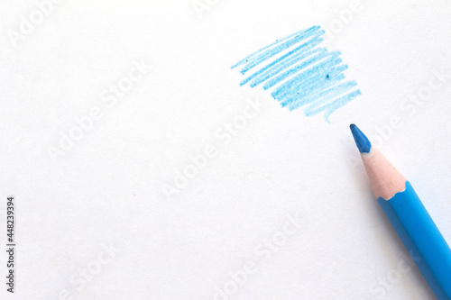 blue pencil with scroll and copy space on white paper . High quality photo
