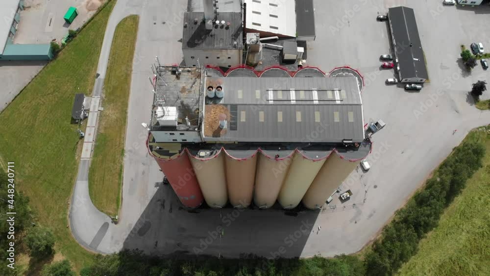 Top down aerial sliding view of Lantmännen Lantbruk industrial crops storage warehouse and large agricultural grains silos located in rural Brålanda town Vänersborg Sweden. Top down aerial sliding view of Lantmännen Lantbruk industrial crops storage warehouse and large agricultural grains silos located in rural Brålanda town Vänersborg Sweden.