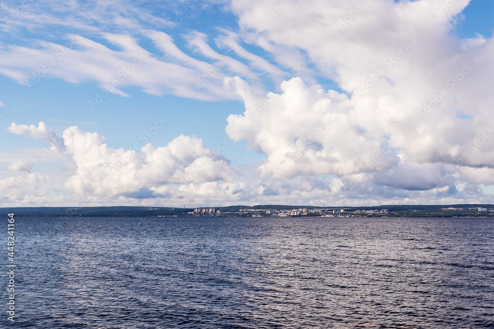 Landscape of blue sky with white clouds over water surface on summer morning. 