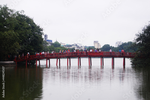 Hoan Kiem pool or Lake of the Returned Sword with The Huc red bridge entrance of Ngoc Son temple for vietnamese people and foreign travelers travel visit at Hoan Kiem on July 7, 2012 in Hanoi, Vietnam photo