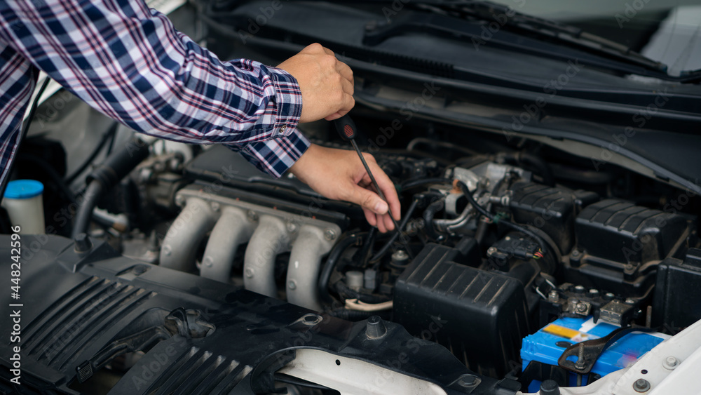 A young man checking and maintaining the engine of his car. Open the hood, check the engine safety before long-distance driving, A young man checking and maintaining the engine of his car. Open the hood, check the engine safety before long-distance driving,