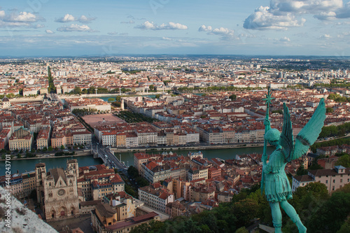 Cityscape de Lyon desde la torre de la Basílica de Fourvière, con una estatua de un ángel presidiendo la vista de la ciudad y la catedral a sus pies 