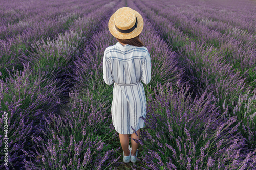 Young woman with lavender bouquet on violet flowers field background