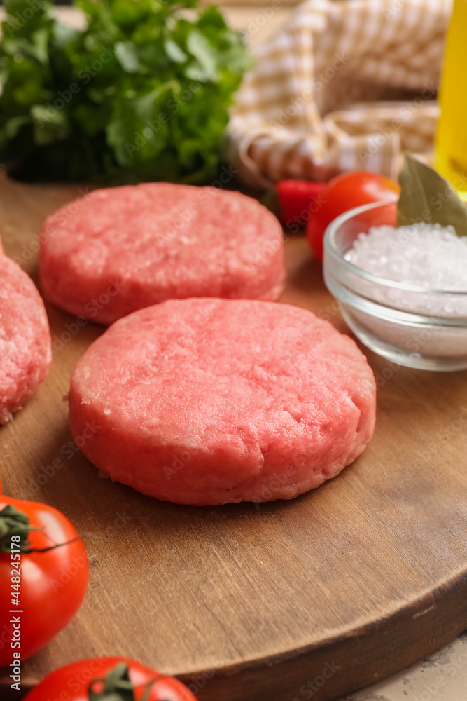Wooden board with raw cutlets made of fresh forcemeat on table, closeup Wooden board with raw cutlets made of fresh forcemeat on table, closeup