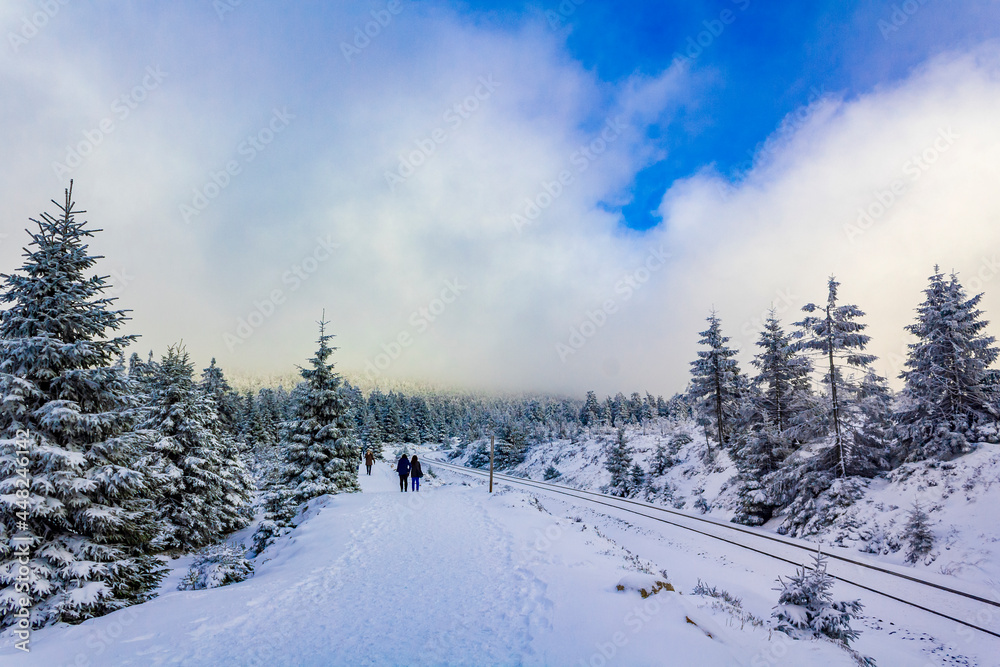 Hikers people in snowed in landscape Brocken mountains Harz Germany.